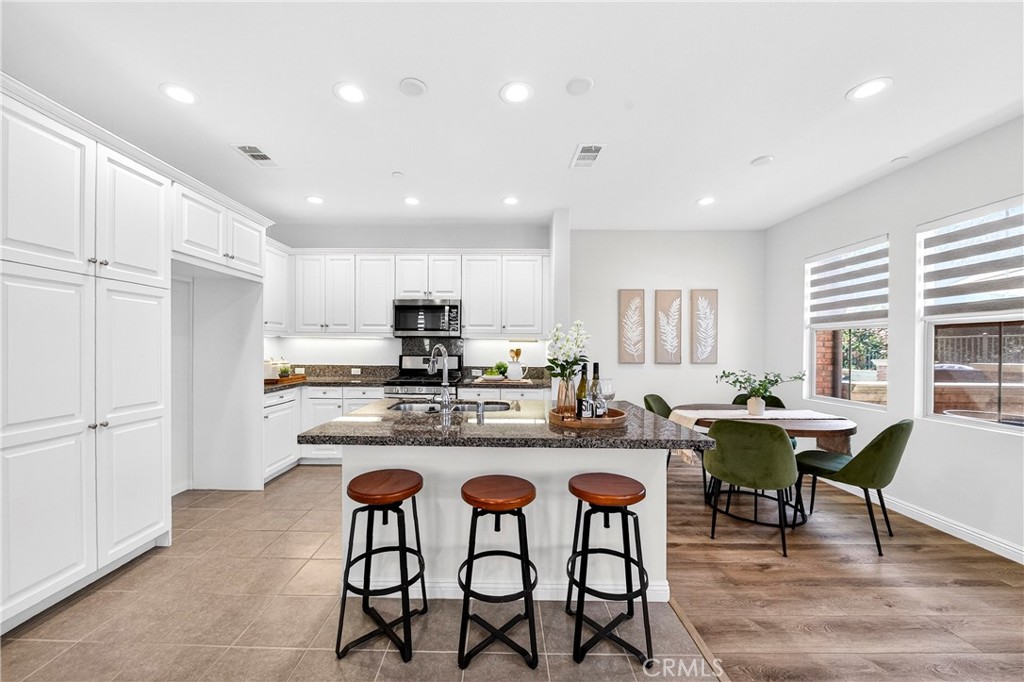 341 Adalina Lane Brea, CA 92821 - Photo 23 of 60 a kitchen with stainless steel appliances granite countertop table chairs sink refrigerator and cabinets