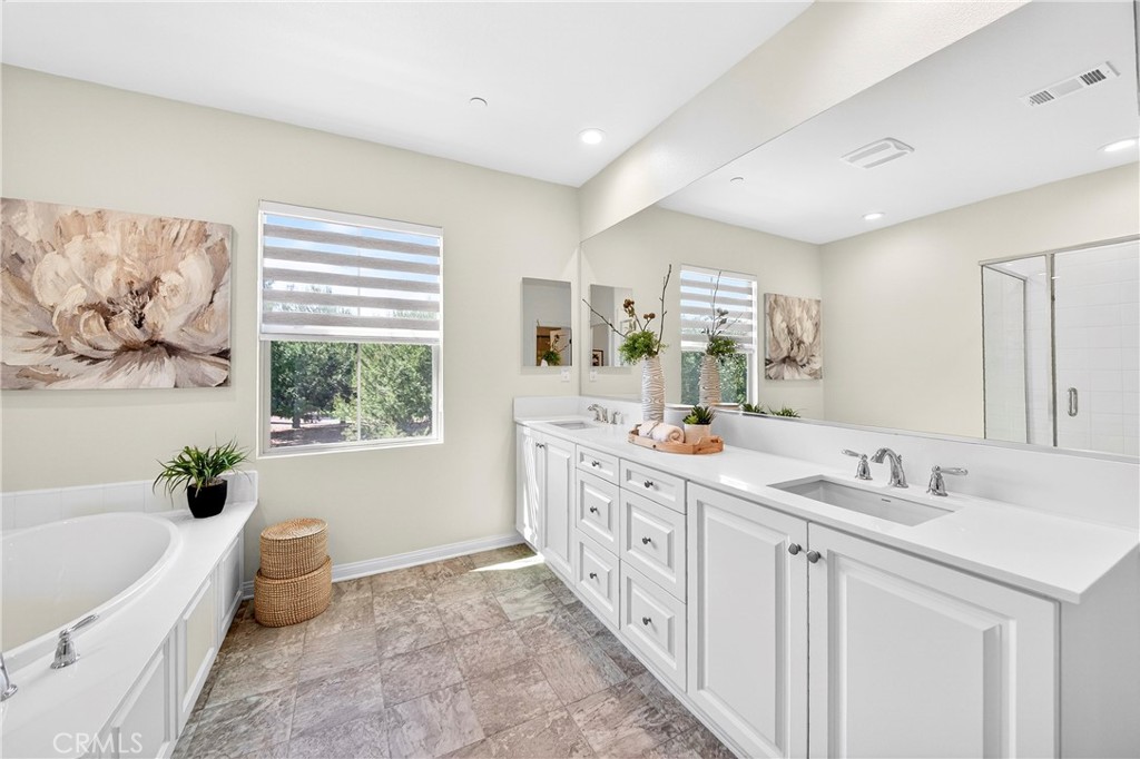 341 Adalina Lane Brea, CA 92821 - Photo 51 of 60 a spacious bathroom with a double vanity sink a large mirror a bathtub and a toilet