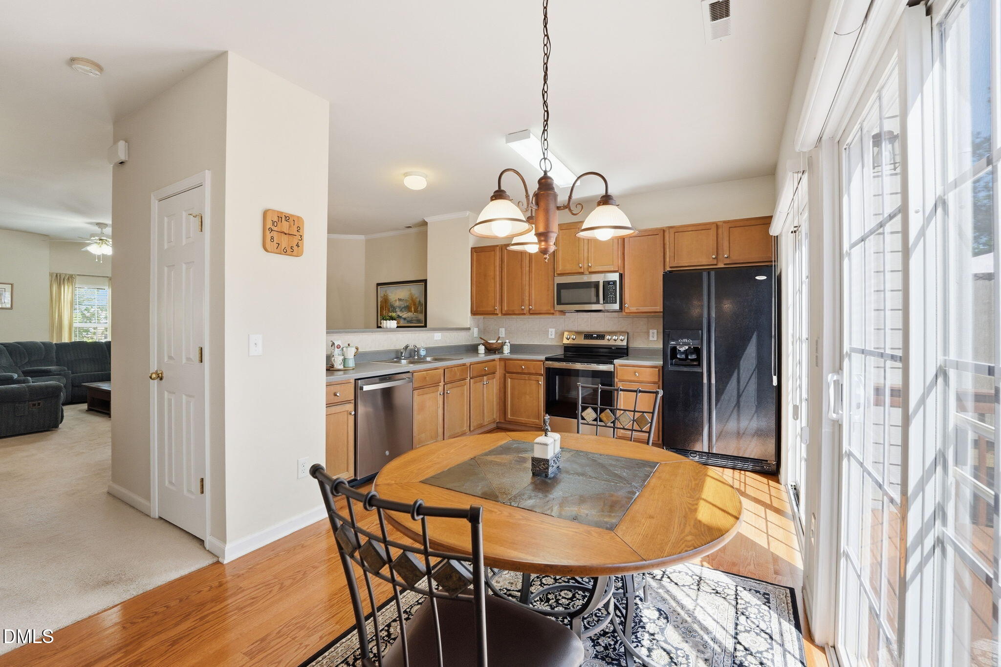 903 Straywhite Avenue Apex, NC 27539 - Photo 7 of 37 a kitchen with stainless steel appliances kitchen island granite countertop a refrigerator a stove a kitchen island a dining table and chairs