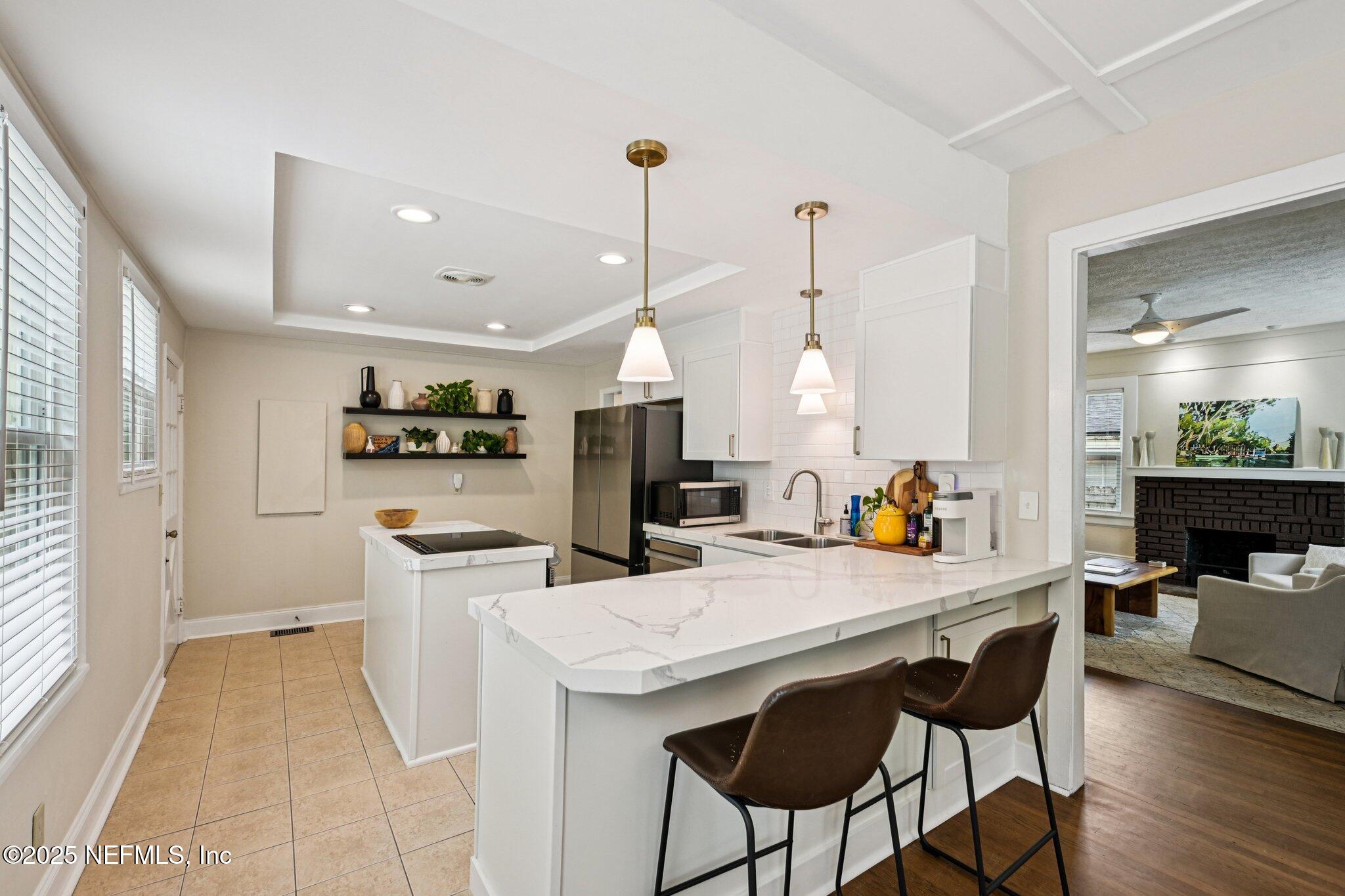 113 Seminole Road Atlantic Beach, FL 32233 - Photo 11 of 52 a kitchen with stainless steel appliances kitchen island granite countertop a dining table chairs and a refrigerator