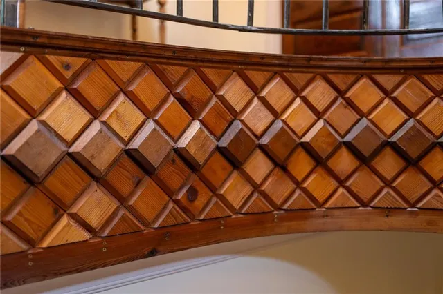 a view of an empty room with wooden floor and windows