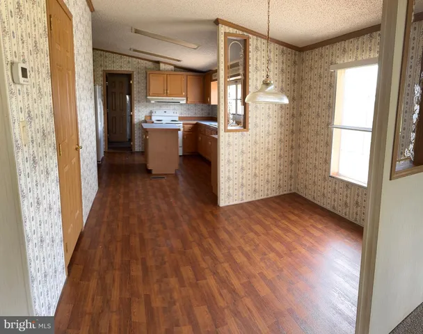 a kitchen with cabinets wooden floor and stainless steel appliances