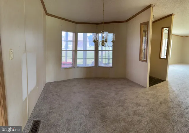 an empty room with a windows and chandelier