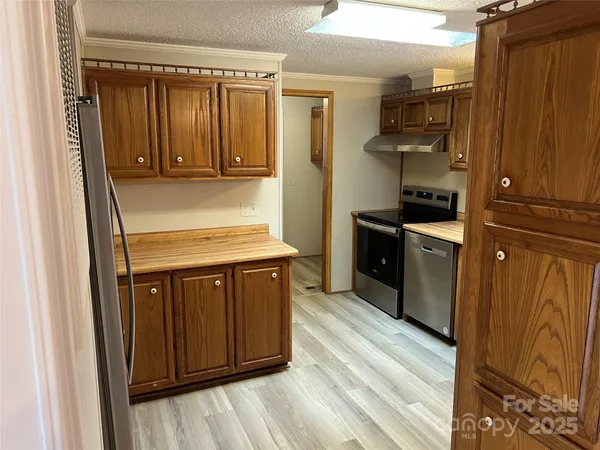 a kitchen with granite countertop wooden cabinets and a stove top oven
