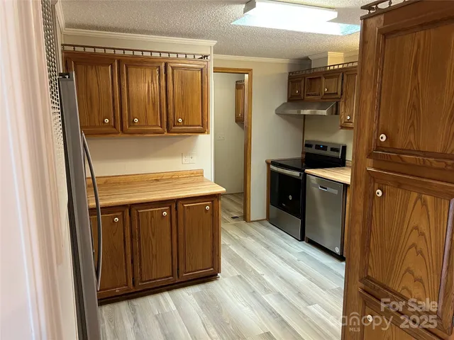 a kitchen with granite countertop wooden cabinets and a stove top oven