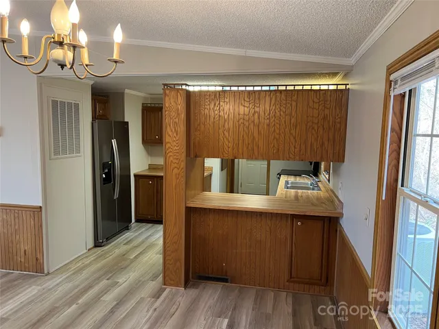 a kitchen with a sink a refrigerator and wooden floor