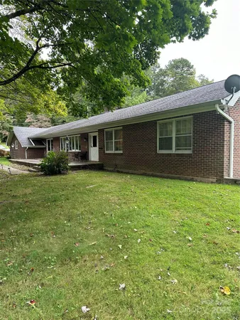 a view of house with yard and outdoor seating