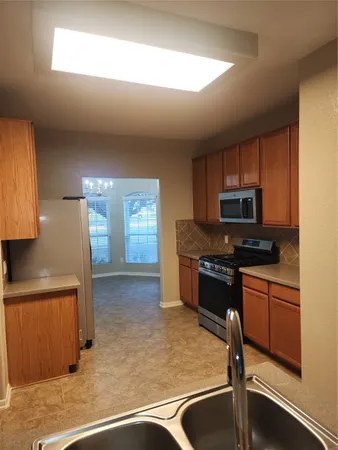 a kitchen with a refrigerator sink and cabinets
