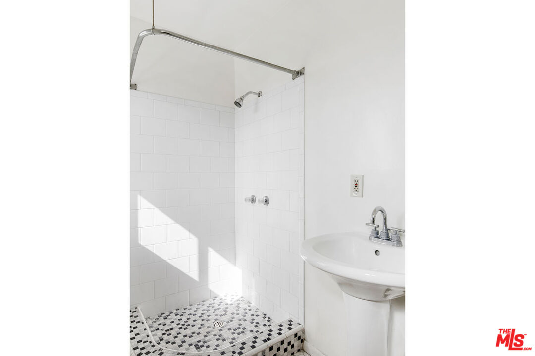 735 Orme Avenue Los Angeles, CA 90023 - Photo 24 of 33 a bathroom with a sink a shower and a mirror