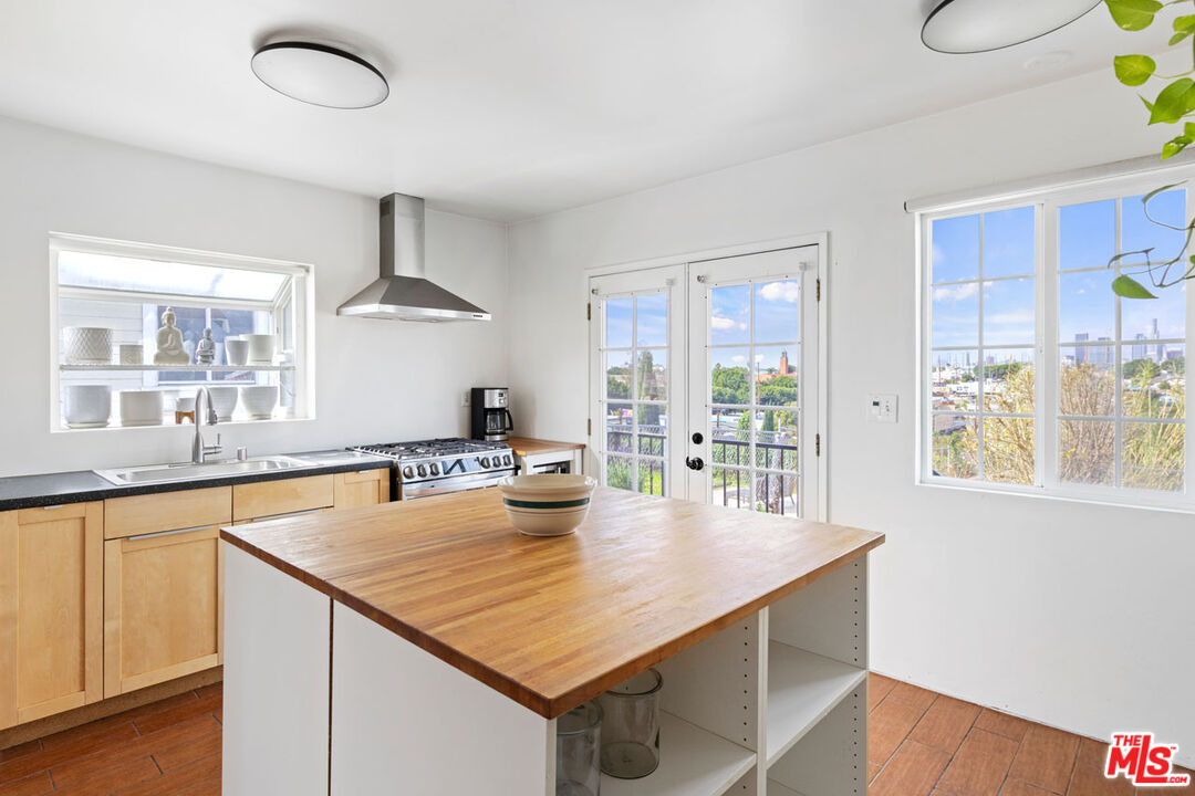 735 Orme Avenue Los Angeles, CA 90023 - Photo 7 of 33 a kitchen with stainless steel appliances granite countertop a sink a stove and a microwave