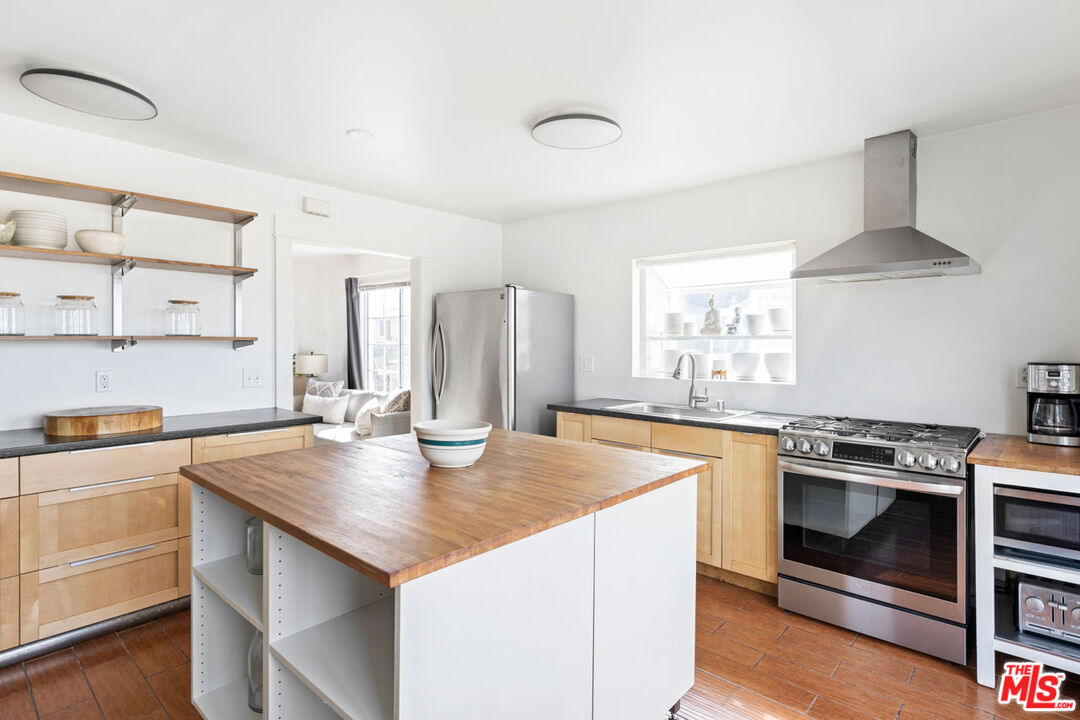 735 Orme Avenue Los Angeles, CA 90023 - Photo 9 of 33 a kitchen with a stove a sink and a refrigerator