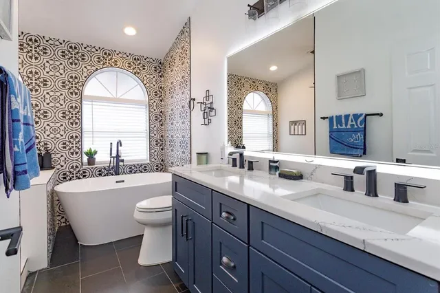 a bathroom with a granite countertop sink mirror and bathtub