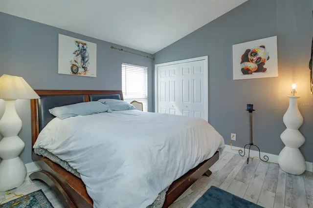 a bedroom with a bed and painting on the wall