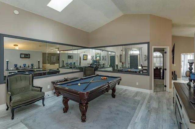 a living room with furniture pool table and chairs