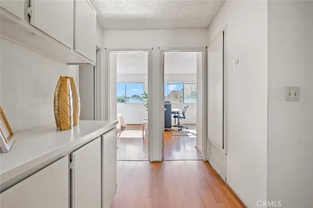 a view of a hallway with wooden floor and a living room