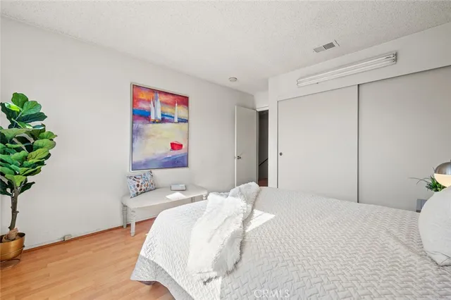 a bedroom with a bed and a potted plant