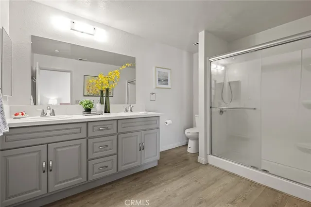 a spacious bathroom with a double vanity sink a toilet and a shower