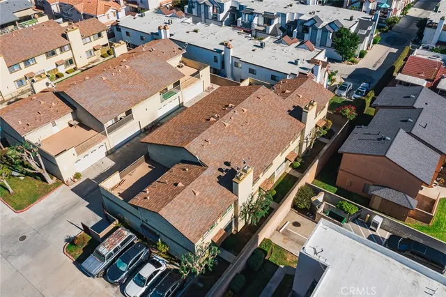 an aerial view of a city with lots of residential buildings and parking space