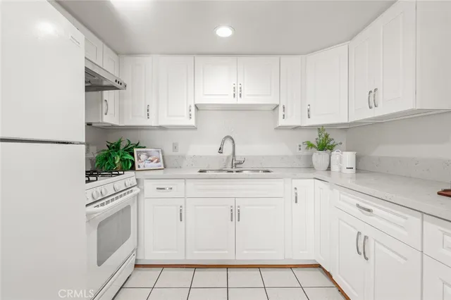 a kitchen with white cabinets stainless steel appliances and sink
