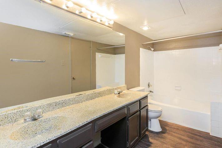 a bathroom with a granite countertop sink a toilet and shower