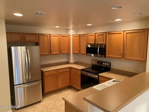 a kitchen with stainless steel appliances granite countertop a refrigerator a sink and a stove