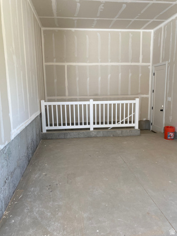 4676 West 75 North, Unit 401 West Point, UT 84015 - Photo 24 of 25 Unfinished interior space featuring a concrete floor, drywall-finished walls, and a white baluster railing