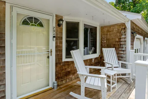 a front view of a house with a garden and trees