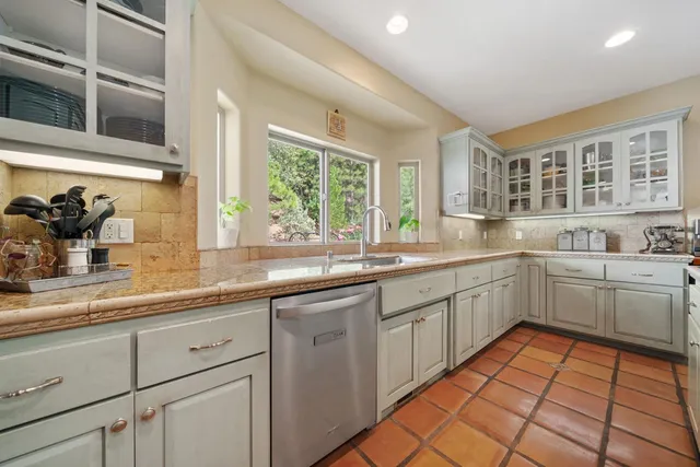 a kitchen with stainless steel appliances granite countertop a sink and a counter top space