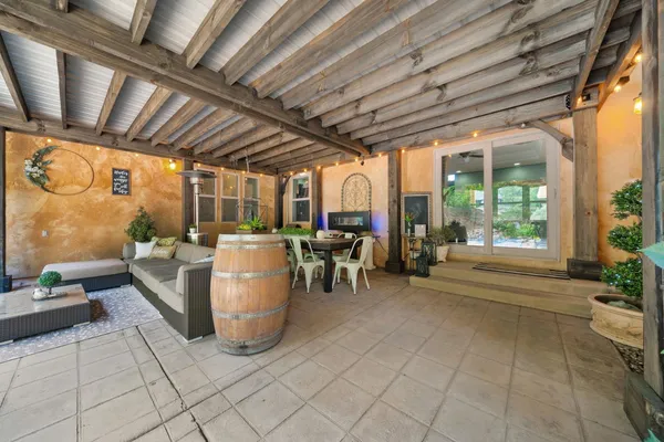 a view of a patio with table and chairs with wooden floor and fence