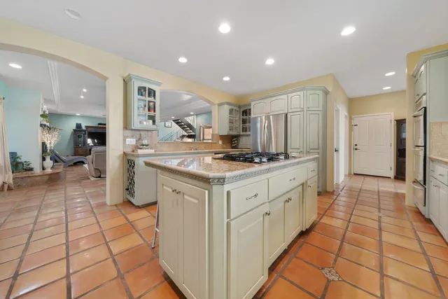 a kitchen with kitchen island granite countertop a sink and cabinets