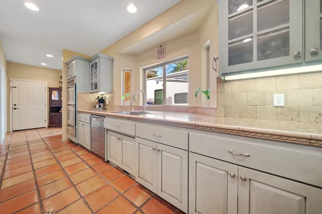 a kitchen with granite countertop a sink stove and cabinets