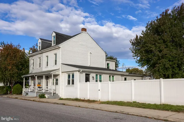 a view of a white house with a large windows and a yard