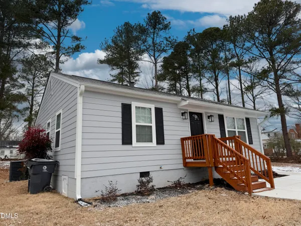 a view of a house with a yard chairs and iron fence