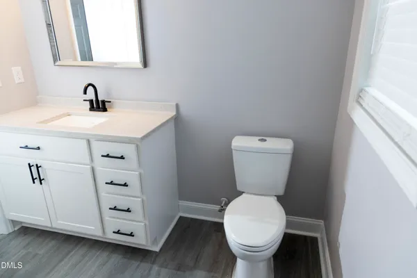 a bathroom with a toilet sink and a mirror