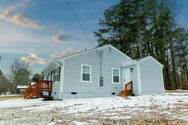 a view of a house with snow in front of it