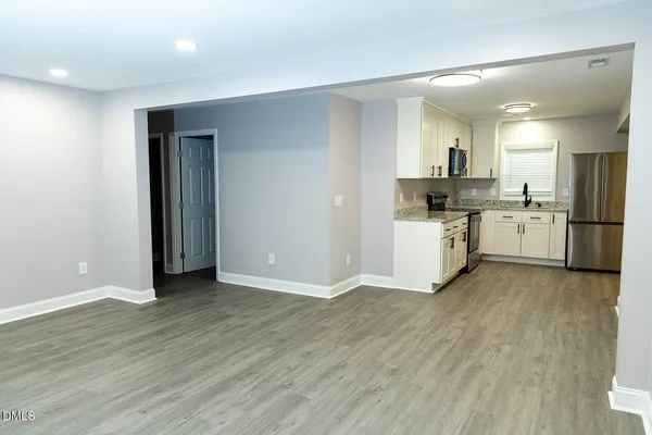 a view of a kitchen with a sink wooden floor and a refrigerator