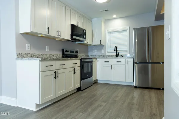 a kitchen with a sink cabinets and stainless steel appliances