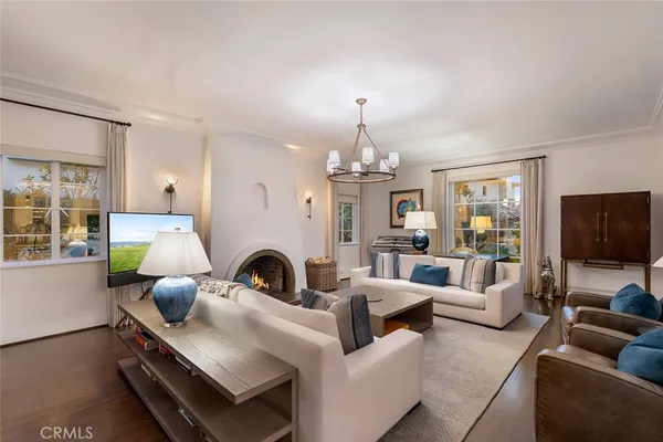 a living room with furniture a chandelier and a flat screen tv
