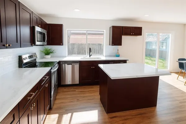 a kitchen with stainless steel appliances granite countertop a sink wooden cabinets and granite counter tops