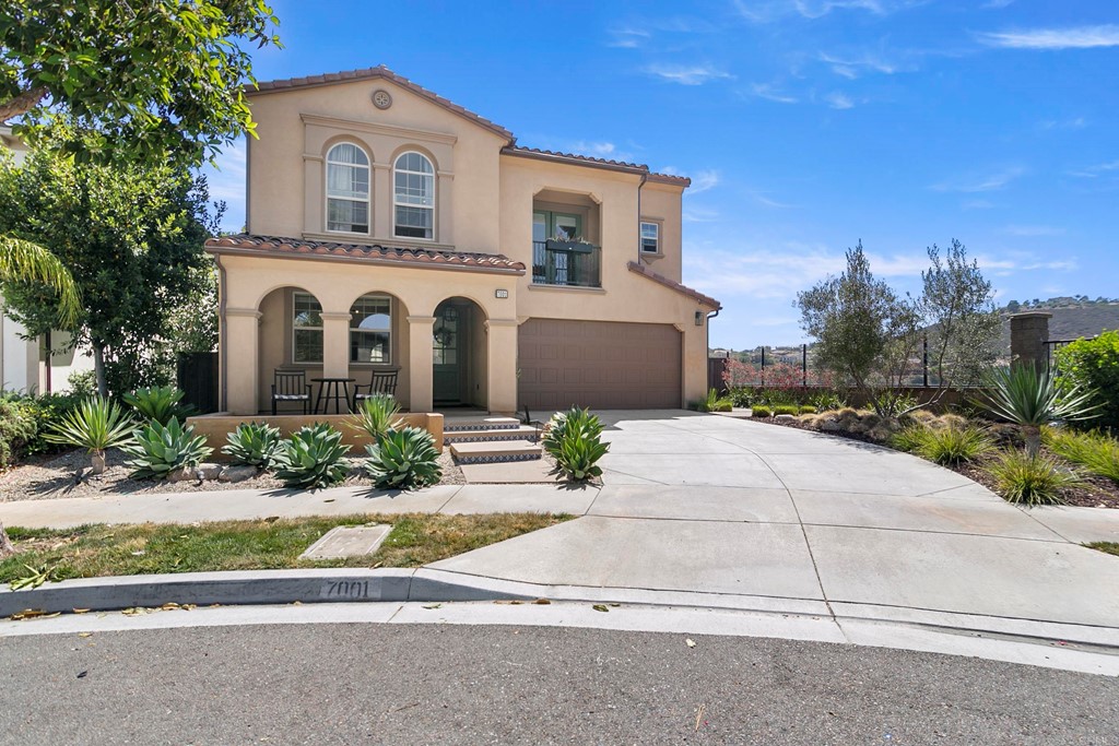 7001 Sitio Frontera Carlsbad, CA 92009 - Photo 2 of 40 a front view of a house with a yard and garage