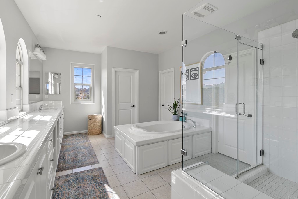 7001 Sitio Frontera Carlsbad, CA 92009 - Photo 31 of 40 a spacious bathroom with a tub sink a shower and mirror