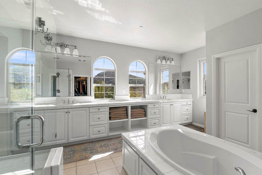 7001 Sitio Frontera Carlsbad, CA 92009 - Photo 32 of 40 a large bathroom with a granite countertop sink and a large mirror