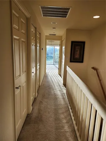 a view of a hallway with wooden floor and windows