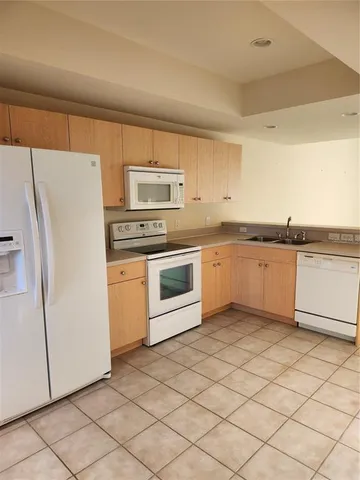 a kitchen with stainless steel appliances granite countertop a refrigerator sink and stove