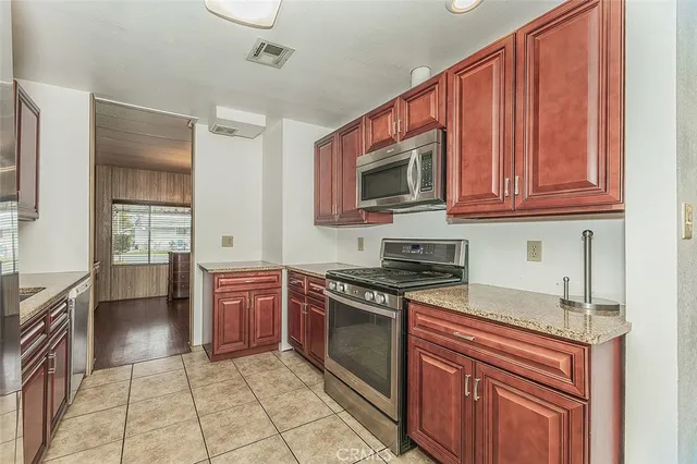 a kitchen with stainless steel appliances granite countertop a stove top oven microwave and cabinets