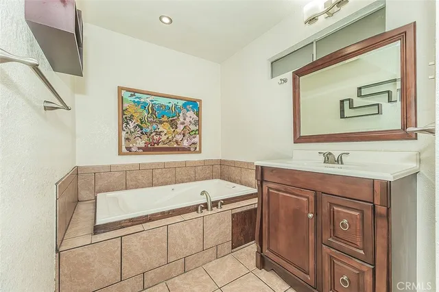 a bathroom with a tub a sink and mirror