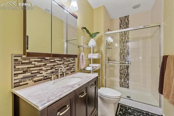 a bathroom with a granite countertop sink toilet and shower
