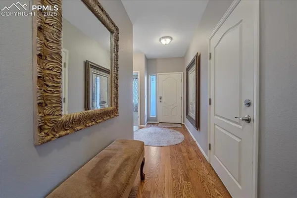 a view of a hallway with wooden floor and cabinet