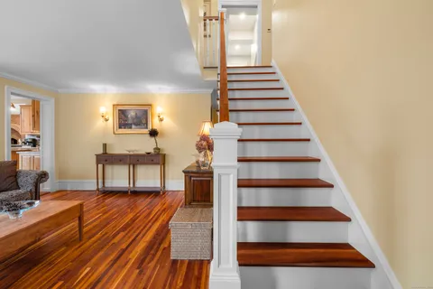 a view of a hallway with wooden floor and staircase