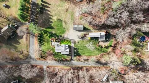 an aerial view of a house with a yard and large trees